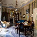 Il vano � arredato con un tavolo in legno, specchi, orologi d�epoca e cristalliere colme di porcellane